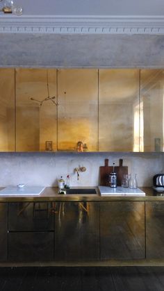 a kitchen with stainless steel cabinets and counter tops, along with a sink in the center