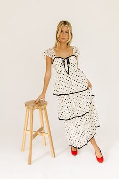 the retro-inspired dress of our dreams. it features sheer short sleeves, a ribbon tie bodice, + dainty ruffle details. both sweet + sophisticated, this off-white + black polka dot midi dress is perfect for fancy dinner dates, holiday parties, + anytime you’re feelin’ frilly. off white + black polka dots // midi length, sweetheart neckline, sheer polka dot sleeves, back zipper closure, tiered skirt, lined model is 5'8" + wearing a small measurements are approximate + taken while laying flat xsmal Retro Inspired Dress, Polka Dot Midi Dress, Dinner Dates, Sheer Shorts, Fancy Dinner, Tier Skirt, Ribbon Tie, Inspired Dress, Black Polka Dot