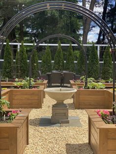 an outdoor seating area with wooden planters and plants in the center, surrounded by trees