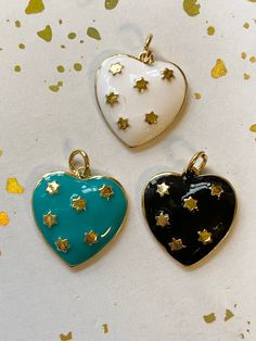 1 Lovely heart charm* or pendant Enamel in white,black and turquoise with gold star accents Solid, nice weight and looks expensive 17mm x 16mm 3mm thick Small jump ring included *Necklaces,charm enhancer, charm connectorand jump rings are not included. They are for idea purposes but may be found in my shop. Charm enhancers in pictures may be found here: Excited to share this item from my #etsy shop: Snap clasp,charm enhancer,16mm,gate clasp,gold vermeil,925 silver,14mm clasp,circle clasp,14K gol White Star Charm Necklace For Gifting, White Star Charm Necklace Gift, White Star Charm Necklaces For Gift, White Star Charm Necklace For Gift, White Pendant Charm Necklaces For Valentine's Day, Gold Enamel Charm Necklace With Heart Charm, Gold Enamel Heart Charm Necklace, White Pendant Charm Necklace For Valentine's Day, Nickel-free White Enamel Charms