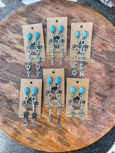 "Here are our punchy turquoise western stone earrings. Choose from 5 different designs: YeeHaw, Cowgirl, Rodeo Queen, Honky Tonk or Y'all.  The letters are stamped with tiny cacti, arrows and more. Certain designs come with additional cute charms.  Made with natural stone set in a burnished silver tone setting. These make a great gift for that Western jewelry lovin family or friend in your life! Measurements:  Width on all is 1 inch Length: Cowgirl- 3.25\" Honky Tonk- 3.75\" Rodeo Queen- 4\" Y'a Cowgirl Earrings, Rodeo Jewelry, Western Turquoise, Engraving Ideas, Turquoise Western, Cowgirl Rodeo, Rodeo Queen, Hippy Gifts, Honky Tonk