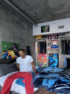 a man sitting on top of a bed in a bedroom