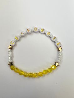 "Handmade beaded friendship bracelet inspired by the Jonas Brothers song \"Celebrate\". Perfect for The Tour and beyond! Bracelet is 7\" long and made with stretchy elastic to fit most adult wrists." Personalized Yellow Friendship Bracelets, Spiritual Beaded Bracelets With Letter Beads For Birthday, Spiritual Letter Beads Beaded Bracelets For Birthday, Spiritual Letter Beads Bracelets For Birthday, Adjustable Spiritual Friendship Bracelets For Birthday, White Beaded Bracelets With Letter Beads For Birthday Gift, White Beaded Bracelets With Letter Beads For Birthday, Yellow Letter Beads Friendship Bracelets As Gift, Gift Yellow Letter Beads Friendship Bracelets