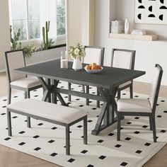 a dining room table with four chairs and a bowl of fruit on top of it