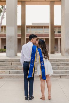 a man and woman kissing in front of a building