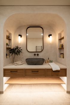 a bathroom with a sink, mirror and shelves