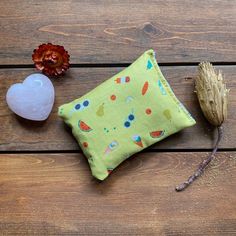 a small pouch sitting on top of a wooden table next to an acorn and flower