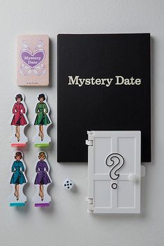 an open book next to several magnets on a white surface with the words mystery date