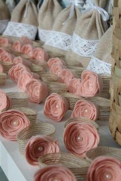 some pink flowers sitting on top of a table next to burlocks and bags