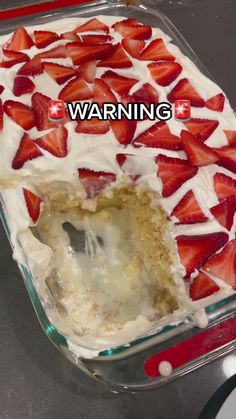 there is a cake with strawberries on it and the words warning in front of it