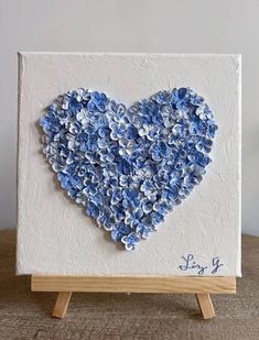 a heart made out of blue flowers on a easel