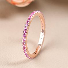 a pink diamond ring sitting on top of a table