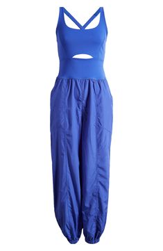 Go for a run in this one-and-done jumpsuit featuring a cutout knit tank with cross-back straps and eased-fit woven track pants. 56" length; 29" inseam; 11" leg opening (size Medium) Partially lined Scoop neck Front slant pockets; back zip pocket Elastic cuffs 68% nylon, 32% elastane with 100% polyester pants Machine wash, tumble dry By Free People; imported Stretch Jumpsuits And Rompers With Elastic Waistband, Sleeveless Summer Activewear With Elastic Waistband, Sleeveless Sportswear Jumpsuits And Rompers For Summer, Sleeveless Sportswear Jumpsuits For Summer, Spring Workout Solid Color Jumpsuits And Rompers, Sleeveless Jumpsuits And Rompers For Yoga In Spring, Casual Jumpsuits And Rompers For Yoga In Spring, Summer Workout Athleisure Jumpsuits And Rompers, Stretch Jumpsuits And Rompers For Spring Sports