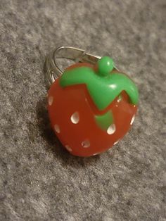 an orange and green ring sitting on top of a gray carpet next to a wall