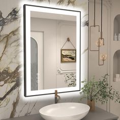 a bathroom sink sitting under a mirror next to a wall mounted faucet with lights on it