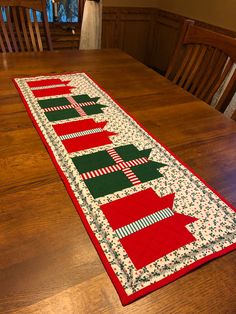 the table runner is decorated with red, green and white christmas stockings on it's sides