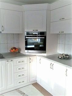 a kitchen with white cabinets and gray counter tops is pictured in this image, there are fruit on the counter