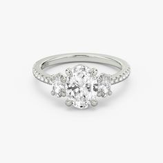 an oval diamond ring with three round diamonds on the band and side stones in white gold