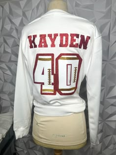 Football Hoodie Ideas, White Sports Fan Tops, White Winter Sports Fan Tops, Football Couples Shirts, Basketball Shirts For Girlfriends, Football Gf Outfits, Football Gf Shirts, Football Girlfriend Shirts Ideas, Football Girlfriend Outfits