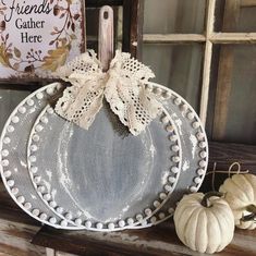 a white plate sitting on top of a wooden table next to pumpkins and a sign