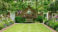 a lush green yard with a bench in the middle