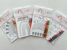 four coloring books with crayons on them