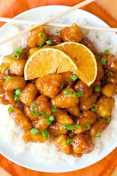 orange chicken on rice with chopsticks and garnish