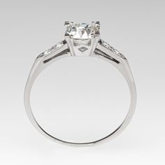 a white gold ring with an oval cut diamond in the center and side stones on each side