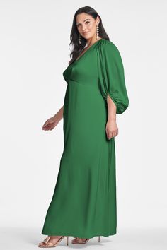 a woman wearing a green dress with sleeves on the shoulders and an open neckline