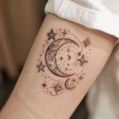 a woman's arm with a crescent and stars tattoo on it