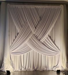 a white curtain draped over a stage with speakers