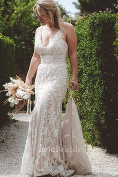 a woman in a wedding dress walking down a path