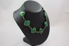 "Our Duckie N56 necklace is fun fun fun!  Featuring large fan shaped chrysocolla, dark teal jade, lime green agate, green Czech glass and brass African Trade Bead roundelles.  It is 18.25\" in length, closes with a brass toggle clasp and is ready to go strut around the office!  READY MADE BEADED NECKLACE * chrysocolla, jade, agate, African Trade Bead, Czech glass necklace * Measures approx. 18.25 inches in length * Ready to wear * Add a additional pair of Arc stud earrings -- see drop down menu Adjustable Green Emerald Necklace With Natural Stones, Unique Green Natural Stone Necklace, Handmade Green Malachite Necklaces, Handmade Adjustable Green Emerald Necklace, Green Jade Beaded Necklaces, Green Chrysocolla Single Strand Necklace, Handmade Bohemian Green Emerald Necklace, Handmade Green Malachite Necklace, Green Malachite Handmade Necklace