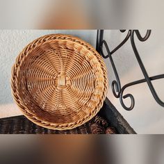 a wicker basket sitting on top of a table next to a wrought iron shelf