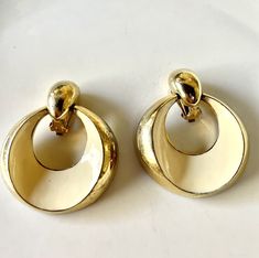 These clip on vintage earrings are so chic and glamorous! Italian style, gold and white (a very elegant off white) circular shape, large earrings that you would expect to see in an Italian vintage fashion magazine, circa 1950's-1960's or a mid century Hollywood movie. They're fabulous- fun and elegant! Height 2 1/4" Width 2" Gold Seventies Inspired Jewelry, White Retro Formal Earrings, White Retro Earrings For Formal Occasions, Retro White Earrings For Formal Occasions, Retro White Clip-on Jewelry, White Vintage Earrings, Retro Gold Round Clip-on Earrings, Retro Round Gold Clip-on Earrings, White Vintage Round Earrings