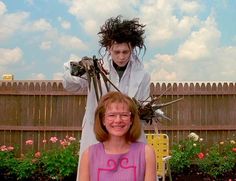 a woman sitting on top of a chair next to a man with hair in the air