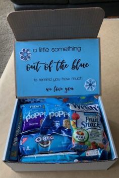 an open box that has some snacks in it and the words out of the blue written on it