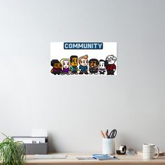 a computer desk topped with an image of people in pixel art style on the wall