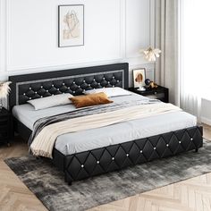 a bed with black leather headboard and foot board in a white walled bedroom area