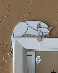 a mirror with a cat decoration hanging from it's side and a star on the door