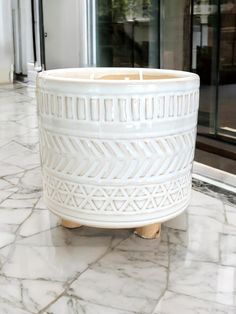 a white planter sitting on top of a marble floor