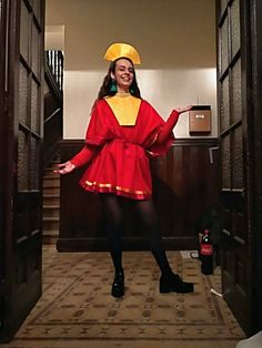 a woman in a red dress and yellow hat posing for the camera with her hands out