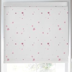 a window with pink stars on it and the blinds in front are closed to let light shine