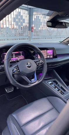 the interior of a car with dashboard, steering wheel and electronic display on the wall