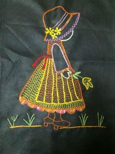 a black cloth with an embroidered image of a woman's dress and hat on it