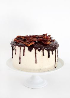 a white cake with chocolate drizzle and bacon on top