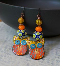 Whimsical owl earrings featuring delightful orange, yellow and blue enamel charms. I love their big mesmerizing eyes. They are topped with spotted blue, green and yellow lampwork beads, bright orange glass spacers, copper beads and yellow Czech glass beads. These earrings measure 2 3/4 inches in total length and hang on niobium earring hooks. Return to shop: bstrung.etsy.com More links where you can find me: Facebook: http://www.facebook.com/bstrung Pinterest: http://pinterest.com/bstrung Instag Artistic Orange Jewelry With Matching Earrings, Orange Enamel Earrings As A Gift, Orange Enamel Earrings For Gifts, Orange Enamel Earrings For Gift, Artsy Orange Jewelry With Matching Earrings, Artistic Orange Dangle Jewelry, Artistic Orange Nickel-free Earrings, Artistic Orange Drop Earrings, Whimsical Enamel Earrings Nickel Free