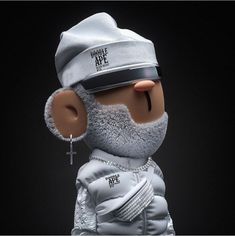 a stuffed animal wearing a white hat and silver jacket with a cross on it's chest