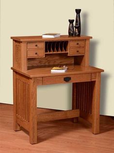 a wooden desk with two drawers and a shelf on the top that holds pens, paper and other items