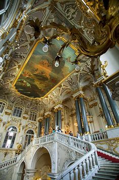 an ornately decorated building with stairs and paintings on the ceiling